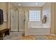 Bathroom with shower, soaking tub, and a wooden bench at 30313 W Mitchell Ave, Buckeye, AZ 85396