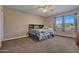 Bedroom with a queen-size bed, ceiling fan, and large windows at 30313 W Mitchell Ave, Buckeye, AZ 85396
