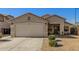 Tan colored house with a two-car garage and desert landscaping at 3206 S 256Th Dr, Buckeye, AZ 85326