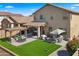Landscaped backyard features an artificial lawn, seating areas, and mature trees, creating a perfect outdoor living space at 3462 E Riopelle Ave, Gilbert, AZ 85298