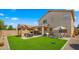 Spacious backyard featuring a manicured lawn, covered patio, pergola and ample seating areas at 3462 E Riopelle Ave, Gilbert, AZ 85298