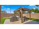 Outdoor seating area with covered pergola, lush green turf, and a stylish patio set at 3462 E Riopelle Ave, Gilbert, AZ 85298