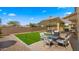 An inviting backyard featuring a green lawn, patio, outdoor furniture, and brick perimeter walls at 3462 E Riopelle Ave, Gilbert, AZ 85298