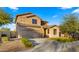 Two-story house with tan exterior, three-car garage, and landscaped yard at 3462 E Riopelle Ave, Gilbert, AZ 85298