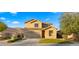 Tan two-story house with a three-car garage and neatly landscaped front yard at 3462 E Riopelle Ave, Gilbert, AZ 85298