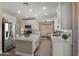 Well-equipped kitchen features an island and stainless steel appliances, with a cozy living area in the background at 3462 E Riopelle Ave, Gilbert, AZ 85298