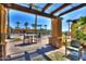 Inviting covered patio offers seating and a scenic view of the pool area and palm trees at 3462 E Riopelle Ave, Gilbert, AZ 85298