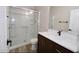 Bathroom features a glass enclosed tiled shower and a dark vanity with a white countertop at 38133 W Vera Cruz Dr, Maricopa, AZ 85138