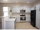 Well-lit kitchen featuring stainless steel appliances, light cabinets, and tile backsplash at 38133 W Vera Cruz Dr, Maricopa, AZ 85138