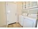 Laundry room with a washer and dryer and a white storage shelving unit above at 38133 W Vera Cruz Dr, Maricopa, AZ 85138
