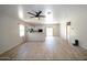 Spacious open concept living room with wood-look flooring, fan and access to kitchen at 38133 W Vera Cruz Dr, Maricopa, AZ 85138