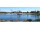 Picturesque view of the community pond with a gazebo and surrounding houses at 38133 W Vera Cruz Dr, Maricopa, AZ 85138