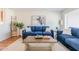 Living room features blue sofas, a coffee table, and hardwood floors at 4205 E Calypso Ave, Mesa, AZ 85206