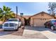 Tan house with a two-car garage and a landscaped yard at 8717 W Wilshire Dr, Phoenix, AZ 85037