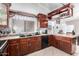 Modern kitchen with dark wood cabinets and stainless steel appliances at 8717 W Wilshire Dr, Phoenix, AZ 85037