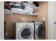 Functional laundry room with washer, dryer, and shelving at 8717 W Wilshire Dr, Phoenix, AZ 85037