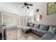 Living room with sectional sofa, ceiling fan, and access to backyard at 8717 W Wilshire Dr, Phoenix, AZ 85037