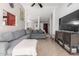Living area with grey sectional, large TV and open floor plan at 8717 W Wilshire Dr, Phoenix, AZ 85037