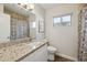 Updated bathroom with granite vanity and patterned shower curtain at 8856 E Altadena Ave, Scottsdale, AZ 85260