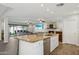 Open kitchen with granite island, stainless steel appliances, and wood flooring at 8856 E Altadena Ave, Scottsdale, AZ 85260