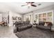 Living room with dark leather sofas, ceiling fan, and large windows at 962 S Jacob St, Gilbert, AZ 85296