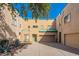 Tan two-story townhome with teal accents, two-car garage, and landscaped courtyard at 1015 S Val Vista Dr # 97, Mesa, AZ 85204