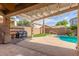 Charming outdoor patio with string lights, barbecue, and refreshing backyard pool at 14995 W Desert Hills Dr, Surprise, AZ 85379
