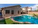 Inviting backyard pool surrounded by lush green grass and desert landscaping for relaxing outdoor oasis at 14995 W Desert Hills Dr, Surprise, AZ 85379