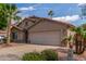 Well-maintained house featuring a two-car garage, xeriscaping, mature shade trees and palm trees at 14995 W Desert Hills Dr, Surprise, AZ 85379