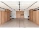 Spacious garage featuring ample wooden cabinet storage along the walls and door to inside at 14995 W Desert Hills Dr, Surprise, AZ 85379