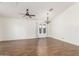 Spacious living room with vaulted ceilings, a ceiling fan, elegant chandelier and wood-look tile flooring at 14995 W Desert Hills Dr, Surprise, AZ 85379