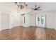 Spacious living room with vaulted ceilings, a ceiling fan, elegant chandelier and wood-look tile flooring at 14995 W Desert Hills Dr, Surprise, AZ 85379