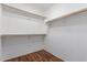 Walk-in closet showing wood-look floors and shelving for clothing storage at 14995 W Desert Hills Dr, Surprise, AZ 85379
