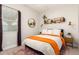 Cozy bedroom with a double bed, and a stylish orange throw at 15320 W Baden St, Goodyear, AZ 85338