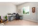 Home office features a large desk, comfortable chair, and natural light at 15320 W Baden St, Goodyear, AZ 85338