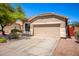 Tan house with a two-car garage and a landscaped front yard at 16940 W Tonbridge St, Surprise, AZ 85374