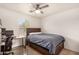Cozy bedroom with a full-size bed, workspace, and ceiling fan at 16958 W Marconi Ave, Surprise, AZ 85388