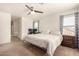 Bright bedroom with a large bed, en-suite bathroom access, and ceiling fan at 16958 W Marconi Ave, Surprise, AZ 85388