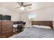 Well-lit bedroom with a full-size bed, workspace, and ceiling fan at 16958 W Marconi Ave, Surprise, AZ 85388