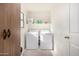 Bright laundry room with washer, dryer, and shelving at 16958 W Marconi Ave, Surprise, AZ 85388