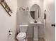 Powder room with pedestal sink, toilet, and decorative wall accents at 18350 W Via Del Sol --, Surprise, AZ 85387