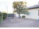 Landscaped backyard with gravel and a large tree, offering privacy at 23886 N 81St Dr, Peoria, AZ 85383