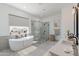 Bright bathroom featuring a modern tub, walk-in shower, dual sink vanity, and elegant decor at 27017 N 153Rd Dr, Surprise, AZ 85387