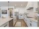 Modern kitchen boasts white cabinets, quartz countertops, and stainless steel appliances at 27017 N 153Rd Dr, Surprise, AZ 85387