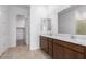 Double vanity bathroom with dark brown cabinets and a view of a closet at 31550 N Hayweather Ln, San Tan Valley, AZ 85143