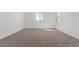 Well-lit bedroom with neutral carpeting and two windows at 31550 N Hayweather Ln, San Tan Valley, AZ 85143
