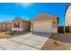 Tan house with a two-car garage and neutral colored driveway at 31550 N Hayweather Ln, San Tan Valley, AZ 85143