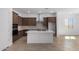 Modern kitchen with dark wood cabinets and a large island at 31550 N Hayweather Ln, San Tan Valley, AZ 85143