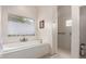 Bathroom featuring a soaking tub, shower, and window with blinds at 31825 N 141St St, Scottsdale, AZ 85262