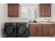 Laundry room with washer, dryer, and wood cabinets at 31825 N 141St St, Scottsdale, AZ 85262